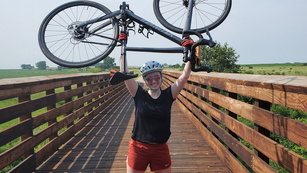 a woman holding a bicycle in the air