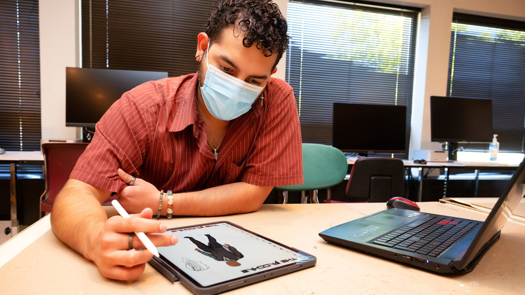 a student designing a theater costume on a tablet