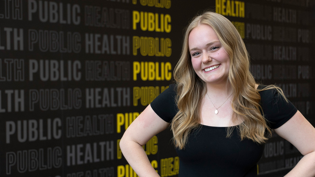 University of Iowa grad Megan Mindy in front of a public health backdrop