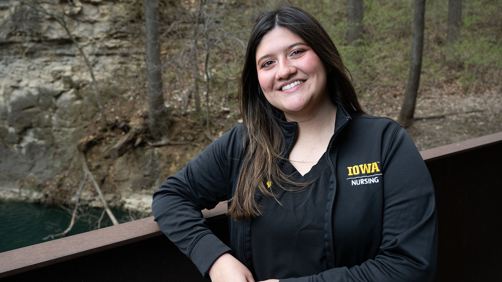 University of Iowa grad Genevieve Martinez standing near the pond by Art Building West