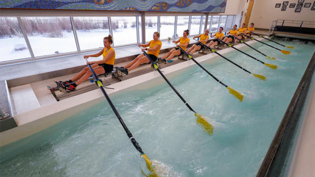 people rowing at a boathouse