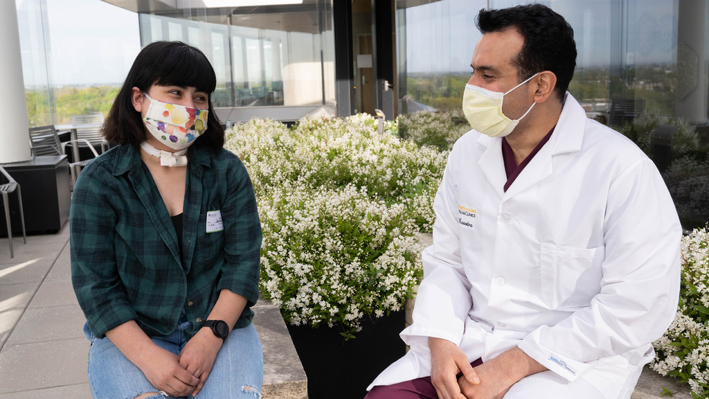 a doctor sits outside with a young patient
