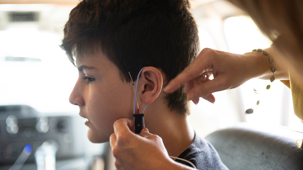 A young boy having his ear measured