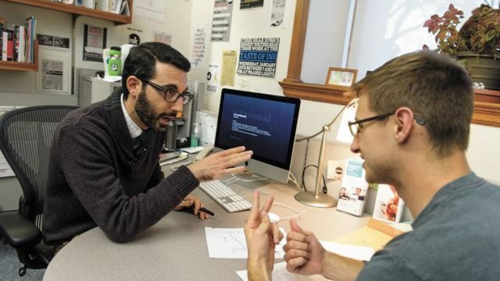 Two people reviewing a paper together