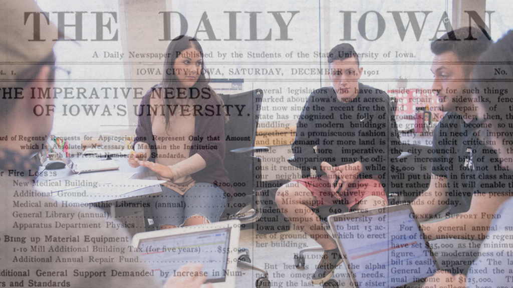 A group of people talking with a cover of "The Daily Iowan" in the background