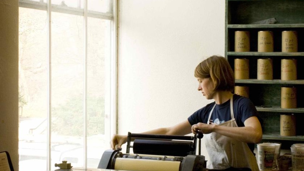 A woman working at a press