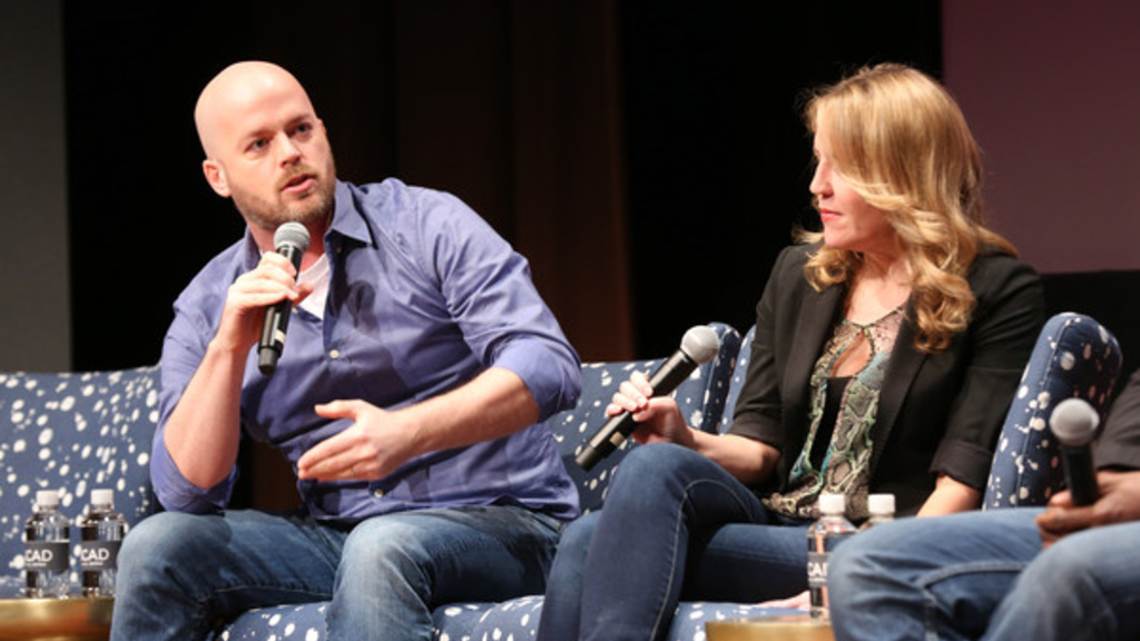 two people sitting on a couch talking