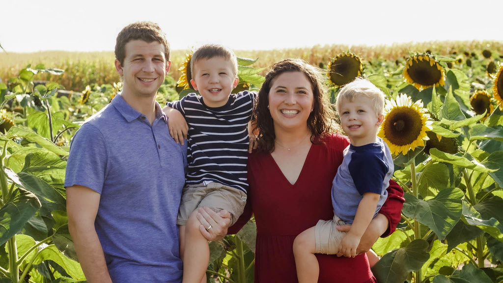 A family standing in a sunflower field