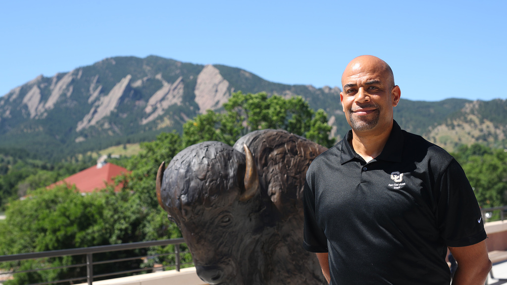 A man standing in front of a statue of a buffalo