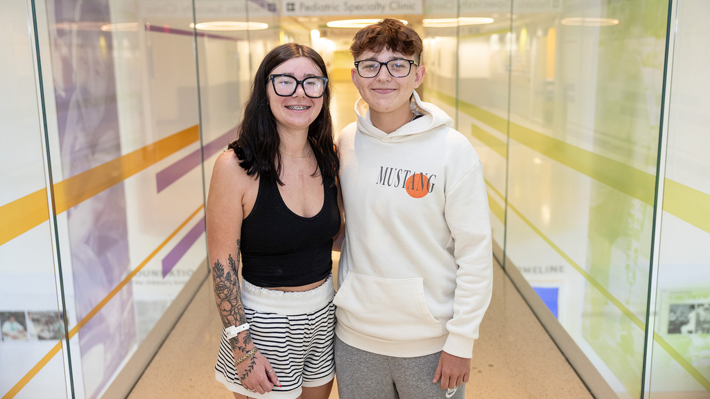 two siblings standing in the hallway of a health care facility