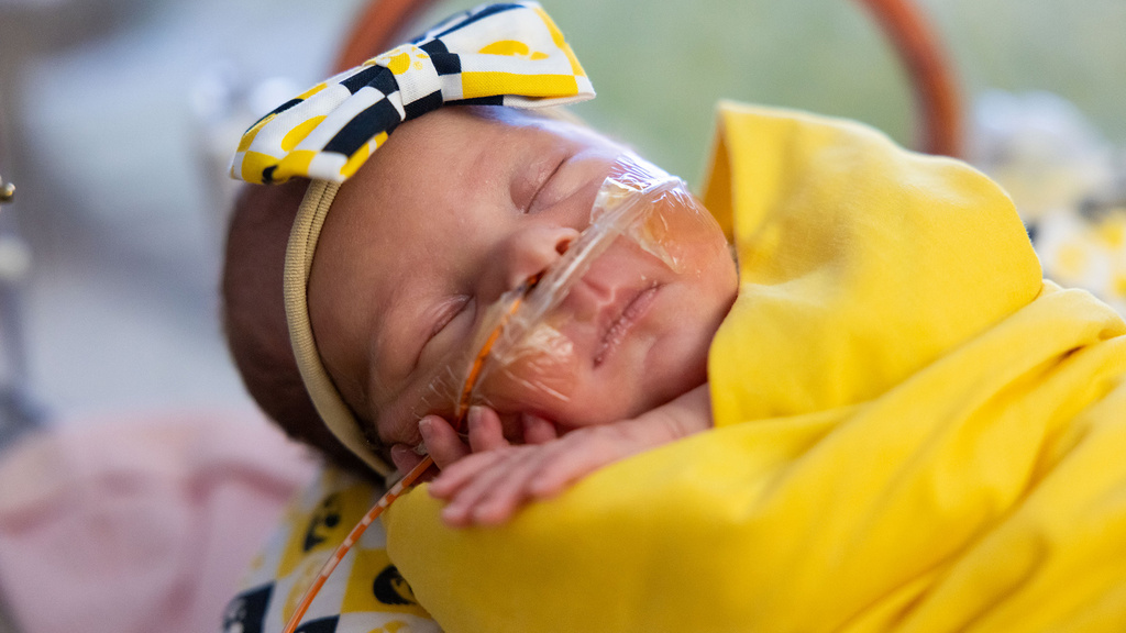 an infant wearing a Hawkeye-themed headband