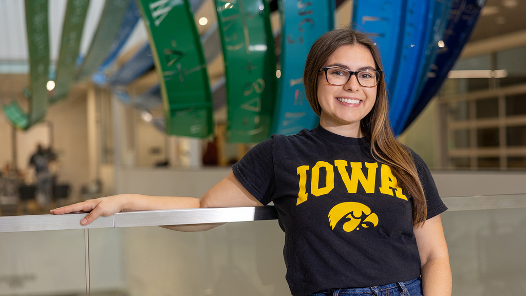 University of Iowa student Juliann Pawlowski, wearing a black-and-gold Iowa shirt, stands on the University of Iowa campus