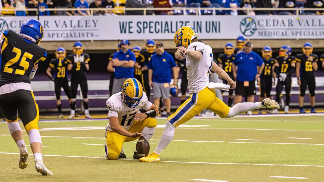 a high school football player kicking an extra point in the Iowa Class 3A state championship game