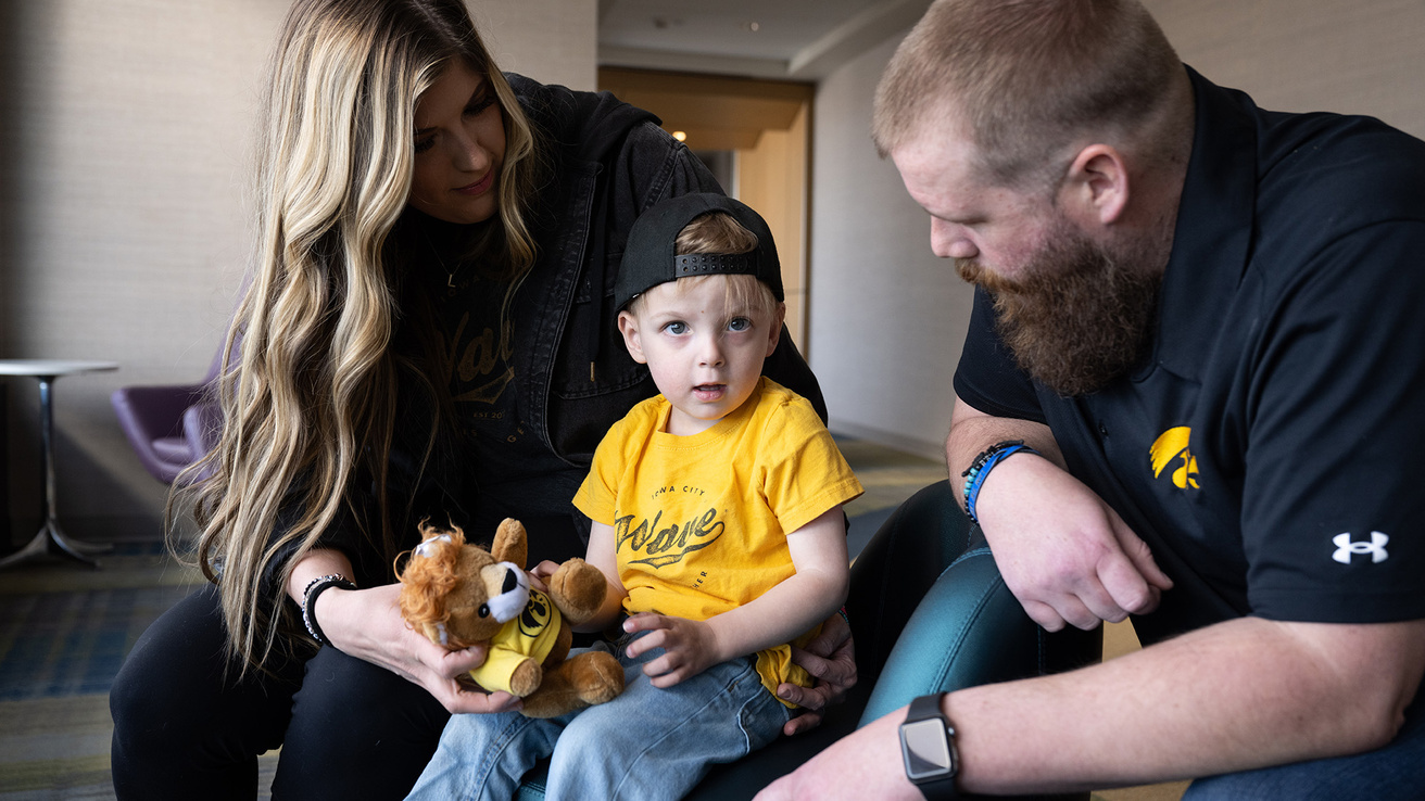 Parents playing with their child with a stuffed animal