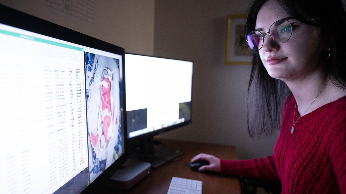 A woman sitting at a computer going over files