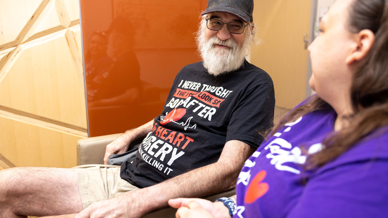 A man sitting in a chair talking to a woman