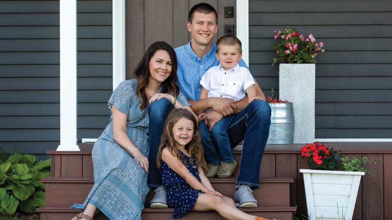 a family sitting on a front stoop for a portrait