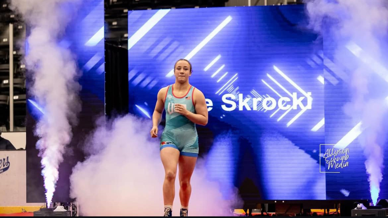 a wrestler enters the arena for competition as smoke machines go off