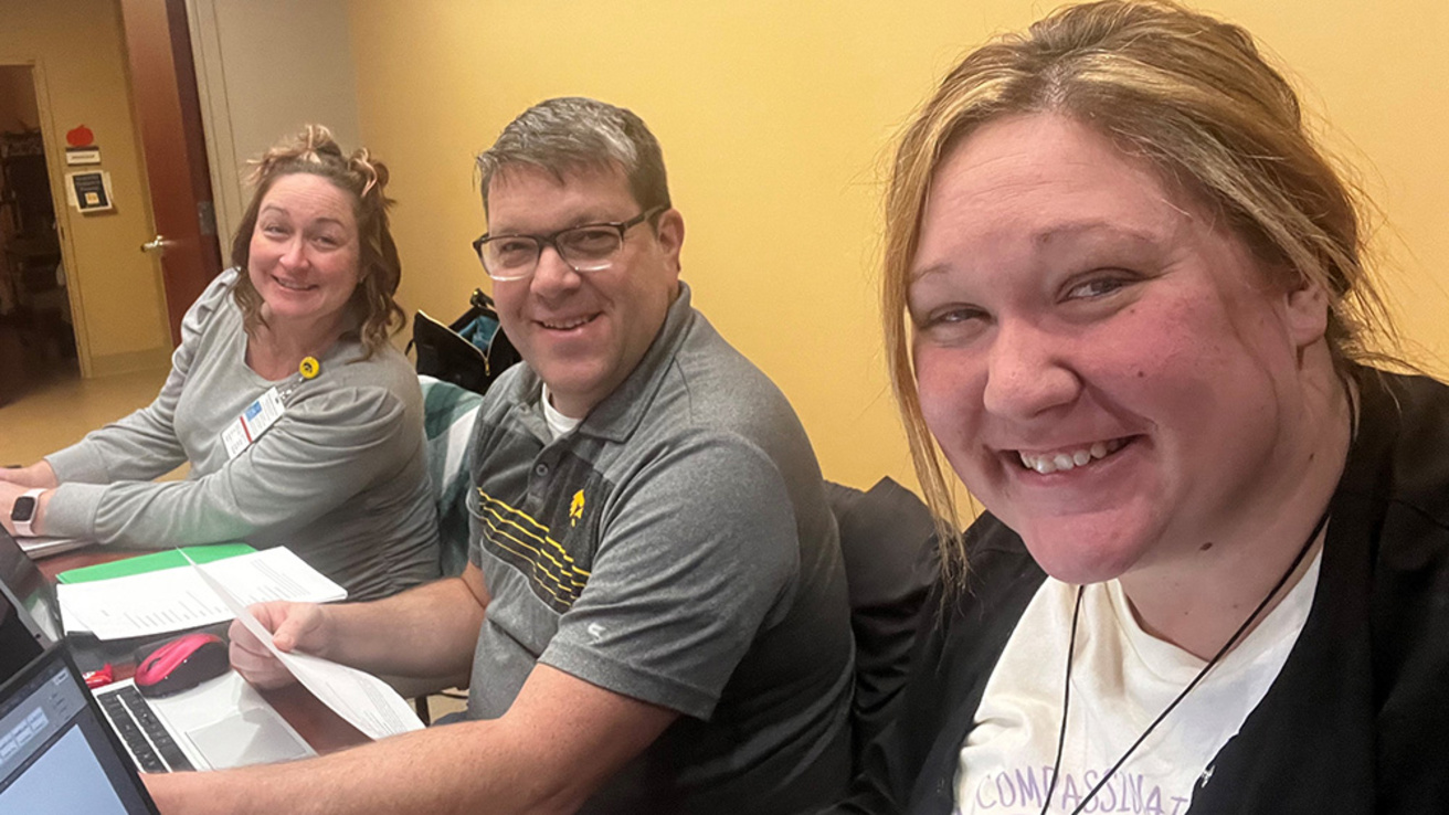 three people smiling while working in a health care facility