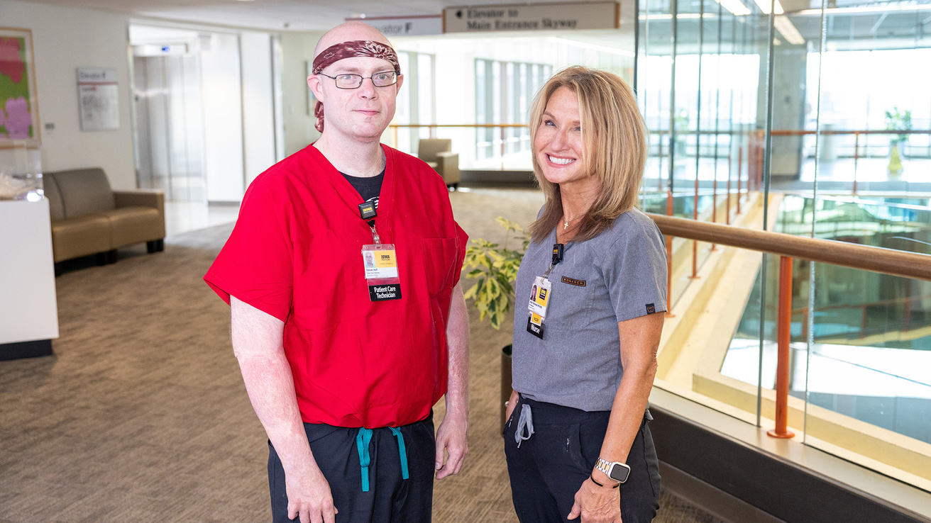 two health care professionals standing in an open area of a health care facility