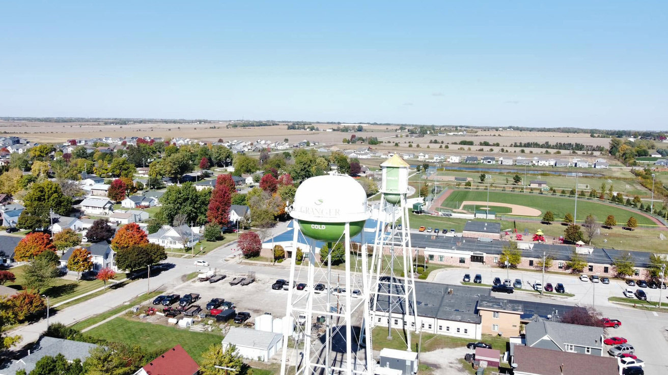 an aerial view of the town of Granger, Iowa, with houses, a water tower, and a baseball field among the things visible