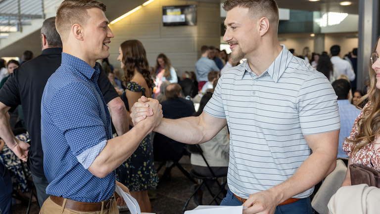 Two men high-fiving each other