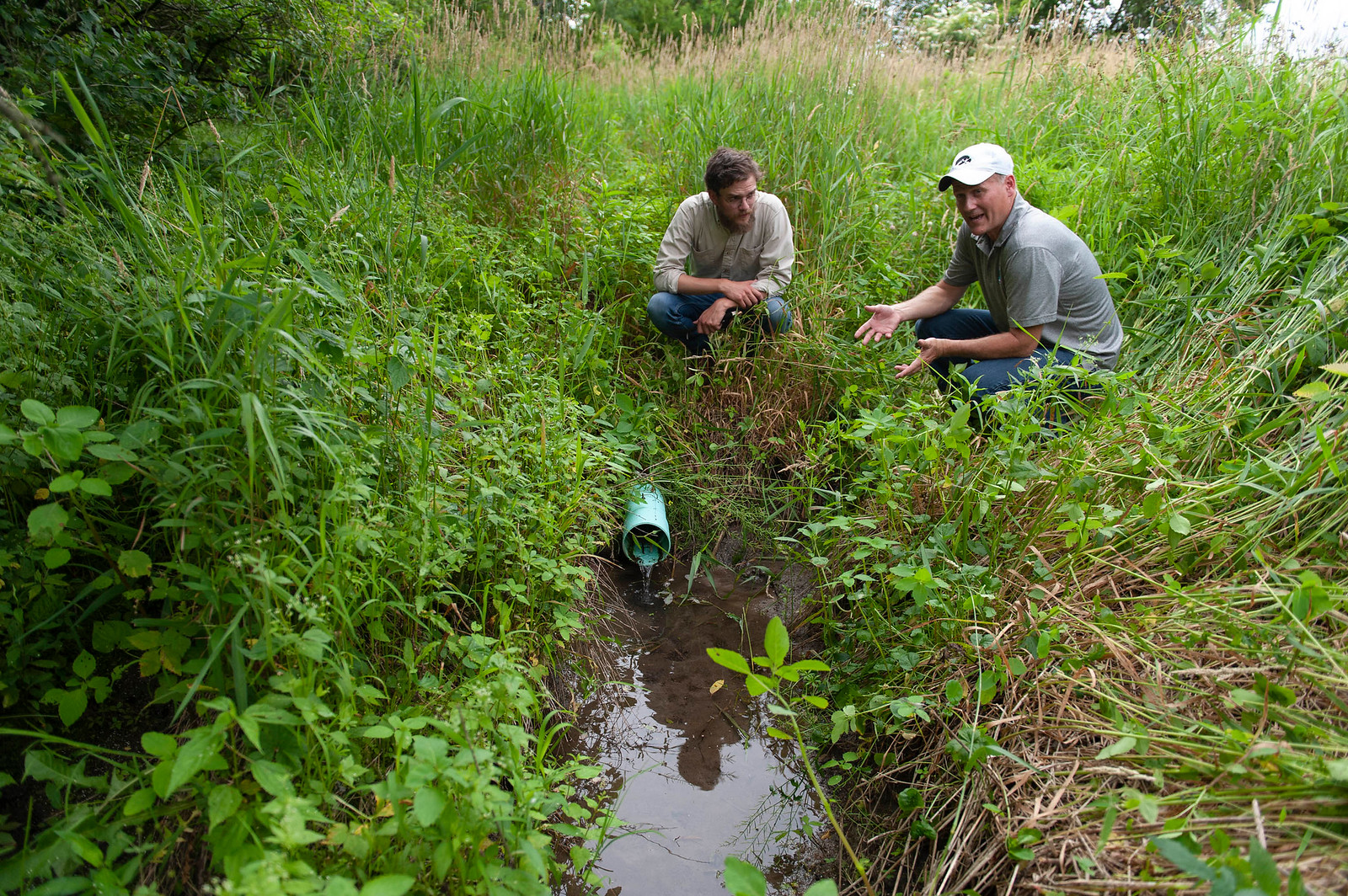 two men speaking in field