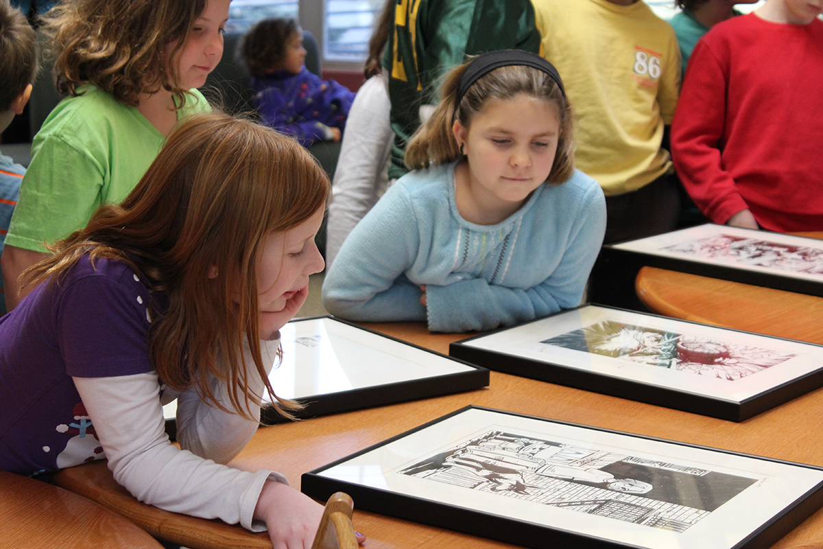 elementary school students look at artwork from the Stanley's collection